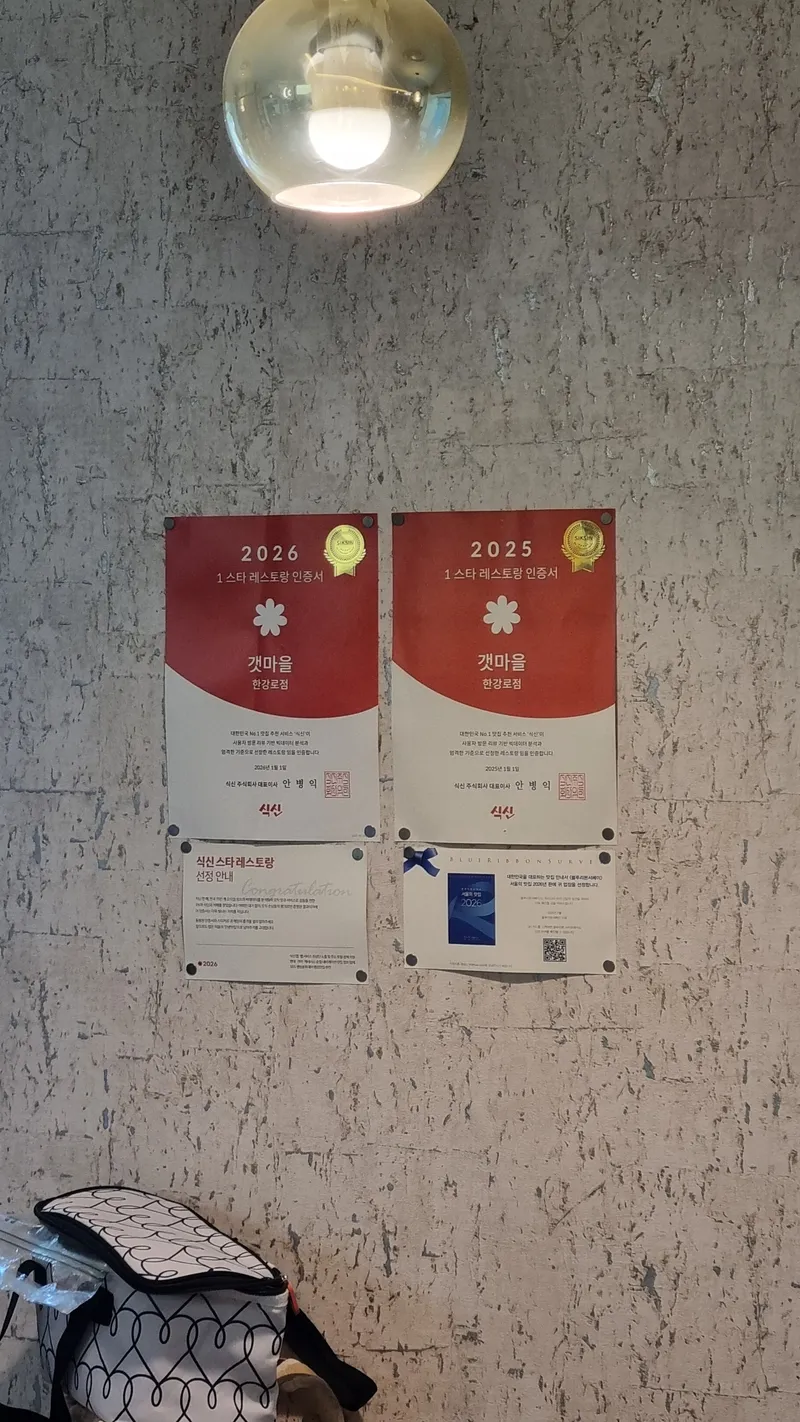 갯마을 한남로점 내부 벽면에 부착된 블루리본 및 식신 레스토랑 인증서