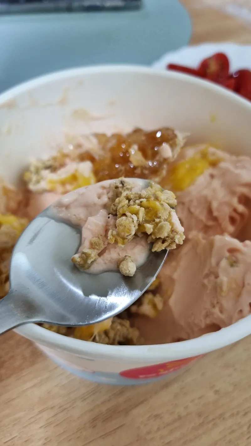 그래놀라 토핑이 섞인 요거트 아이스크림 한 숟가락