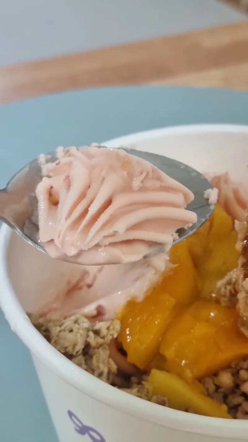 핑크빛 토마토 요거트 아이스크림을 숟가락으로 뜬 모습