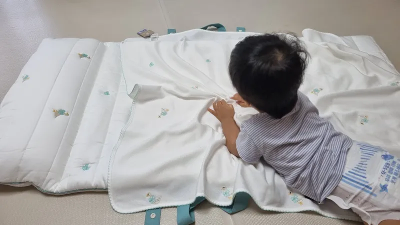 22개월 아기가 직접 낮잠이불 위에 누워 이불을 만져보는 모습