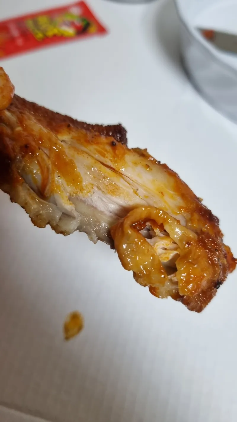 베어 물어 하얀 속살이 드러난 버팔로 치킨윙 단면