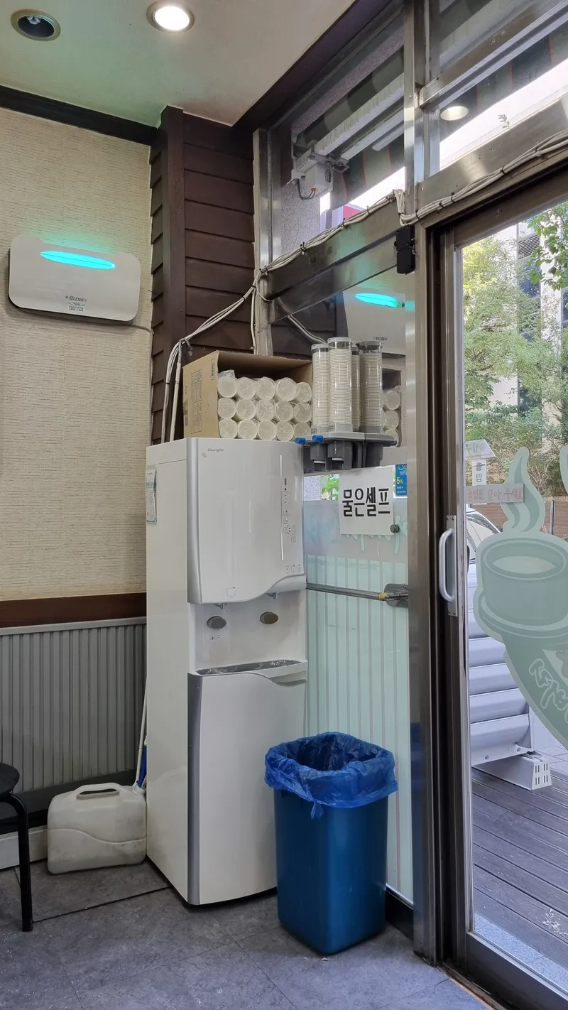 물은 셀프 문구가 붙은 정수기와 출입구 내부