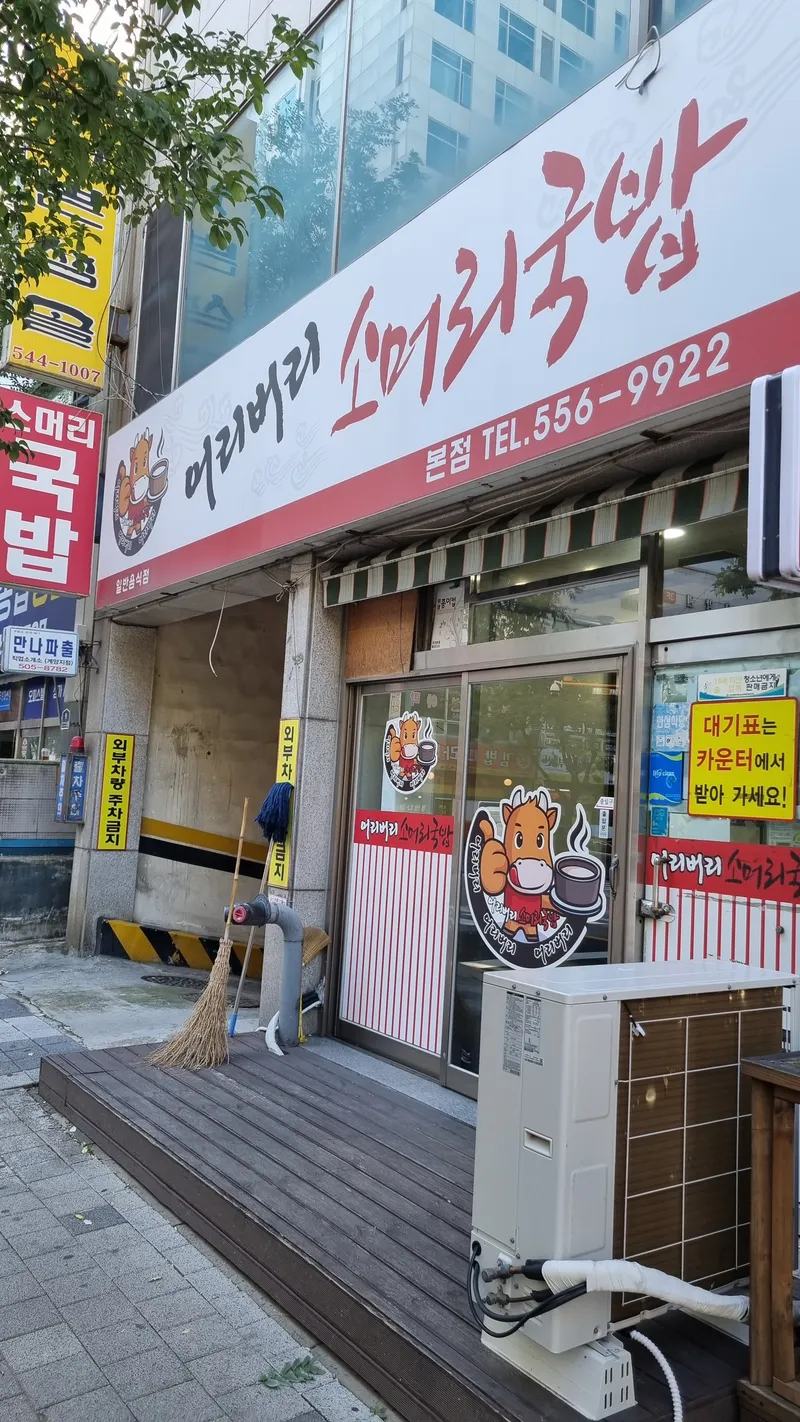 붉은색 상호 간판과 대기표 안내문이 붙은 식당 외부 전경